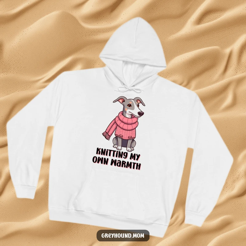 Funny Greyhound hoodie, dog in a snug sweater, diligently knitting a long scarf, radiating warmth and creativity. Perfect funny gift for knitters.