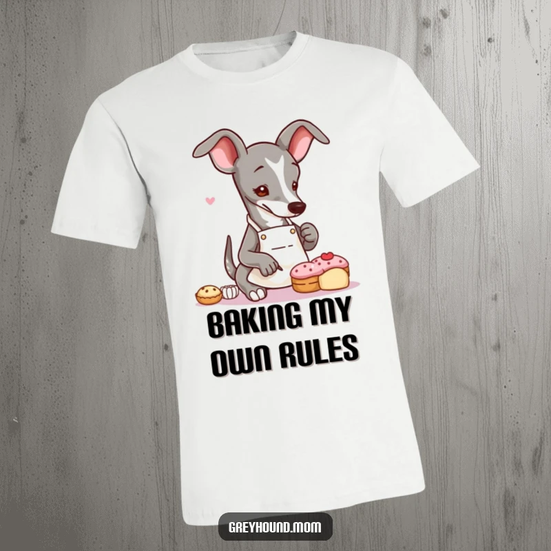 Funny Greyhound baker t-shirt featuring a slender dog in an apron, meticulously decorating a tiny pastry with artistic focus.